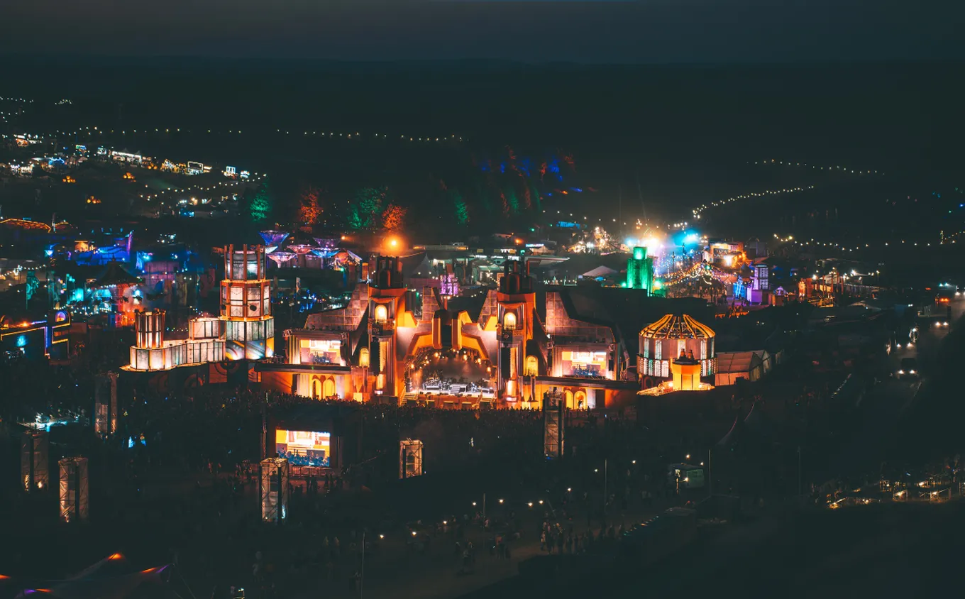Cameo Light Installation at Boomtown Festival 2025 with drone view on the festival area with illuminated stages stage design and colourful light beams