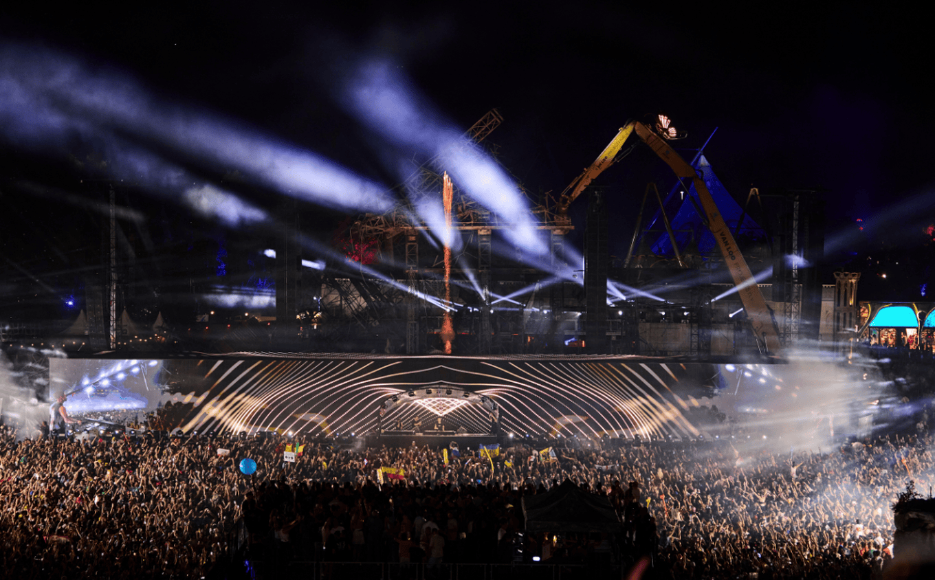 Cameo Light ZENIT W300 Wash Lights on Main Stage Tomorrowland 2025 with light beams and the Ruins of burnt stage in the background