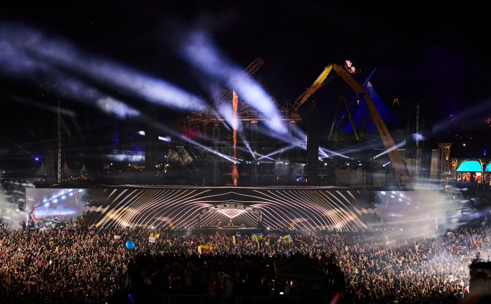 Cameo Light ZENIT W300 Wash Lights on Main Stage Tomorrowland 2025 with light beams and the Ruins of burnt stage in the background