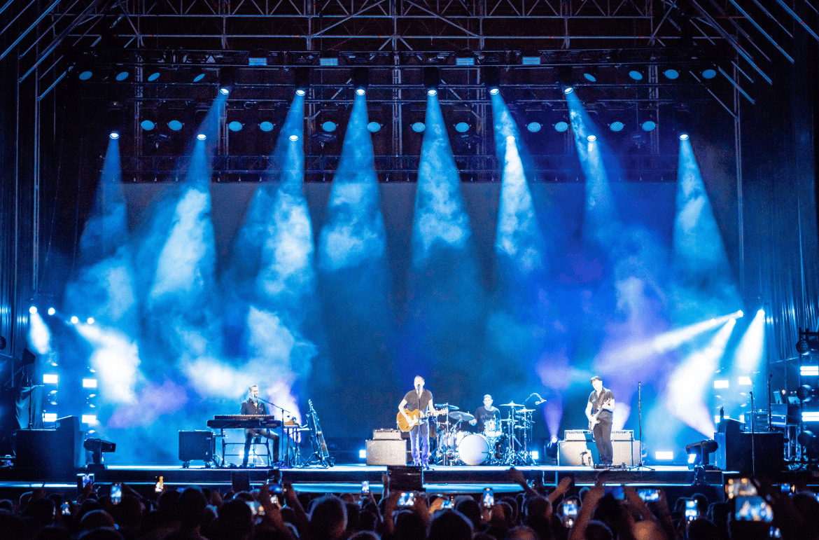 Cameo OPUS X4 profile moving heads in action during a Bryan Adams concert – producing crisp blue beams from the truss, highlighting their precise output and stage presence.