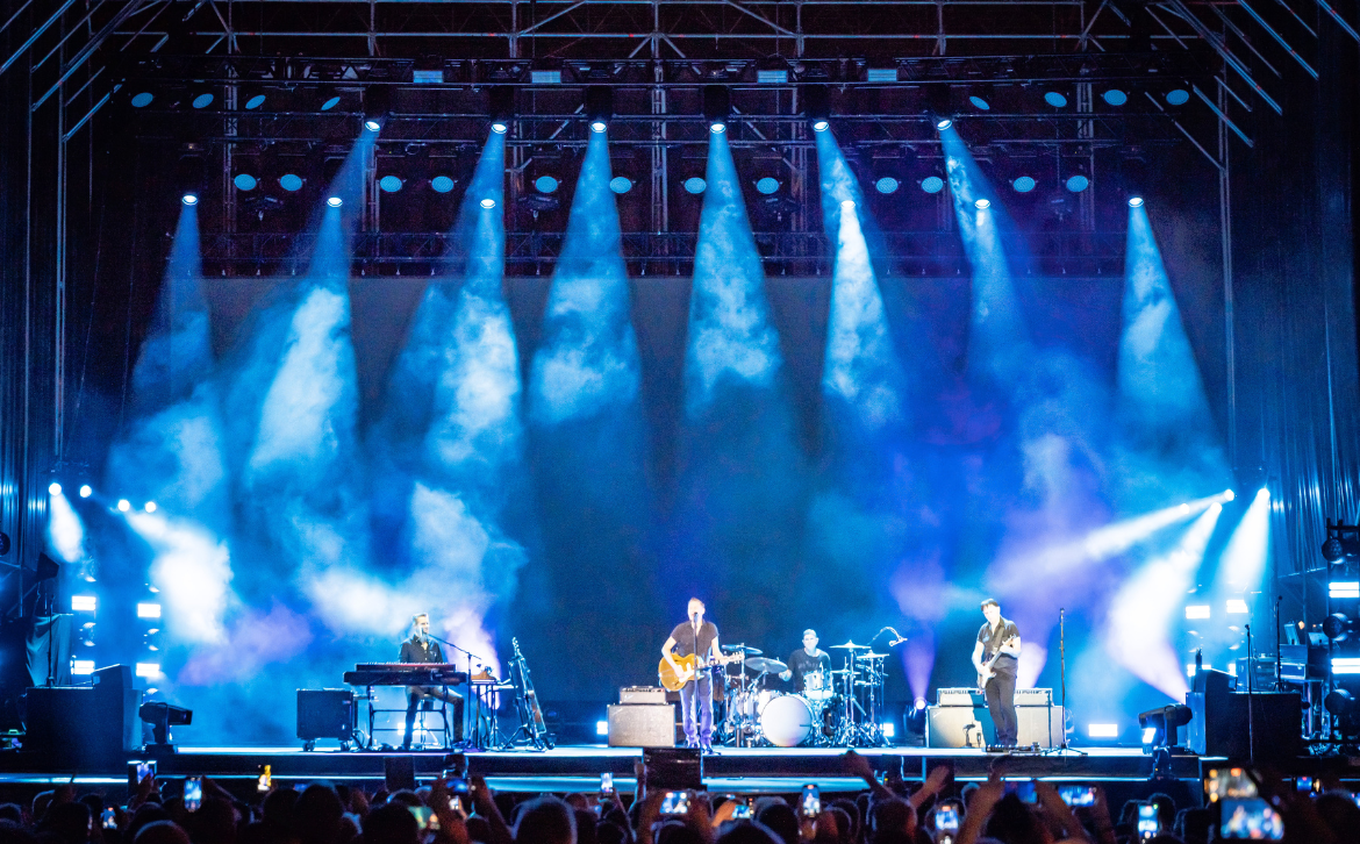 Cameo OPUS X4 profile moving heads in action during a Bryan Adams concert – producing crisp blue beams from the truss, highlighting their precise output and stage presence.