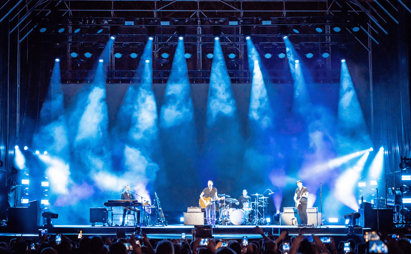 Cameo OPUS X4 profile moving heads in action during a Bryan Adams concert – producing crisp blue beams from the truss, highlighting their precise output and stage presence.